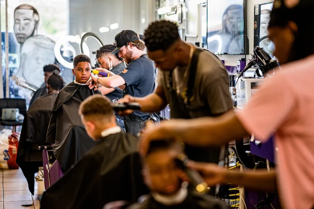 Barbers cutting clients' hair