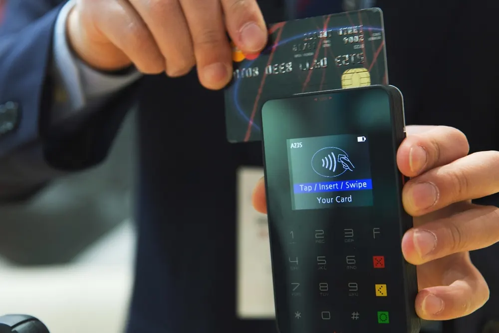 A client tapping a card to pay a deposit